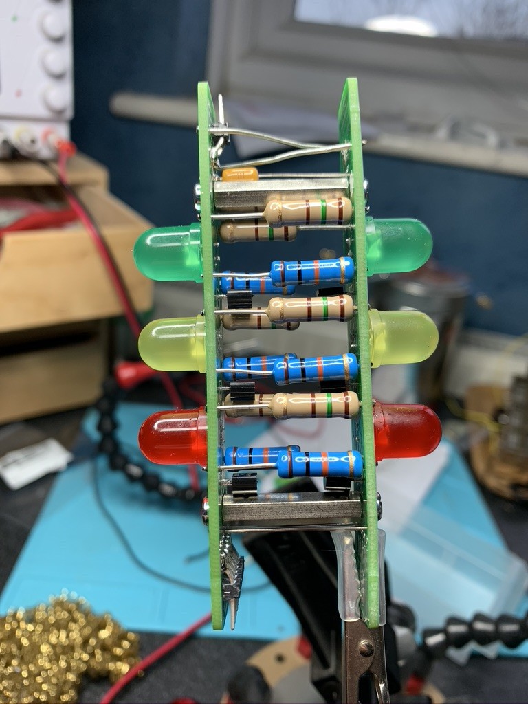 The completed puzzle: two PCBs, side-on, with 6 LEDs, 6 resistors on a plane parallel with the camera and another 6 behind. There are also standoffs connecting the boards and some jumpers running between them. 