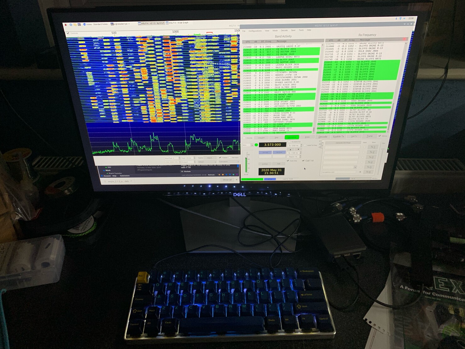 A monitor showing WSJT-X and a glowing mechanical keyboard underneath. 