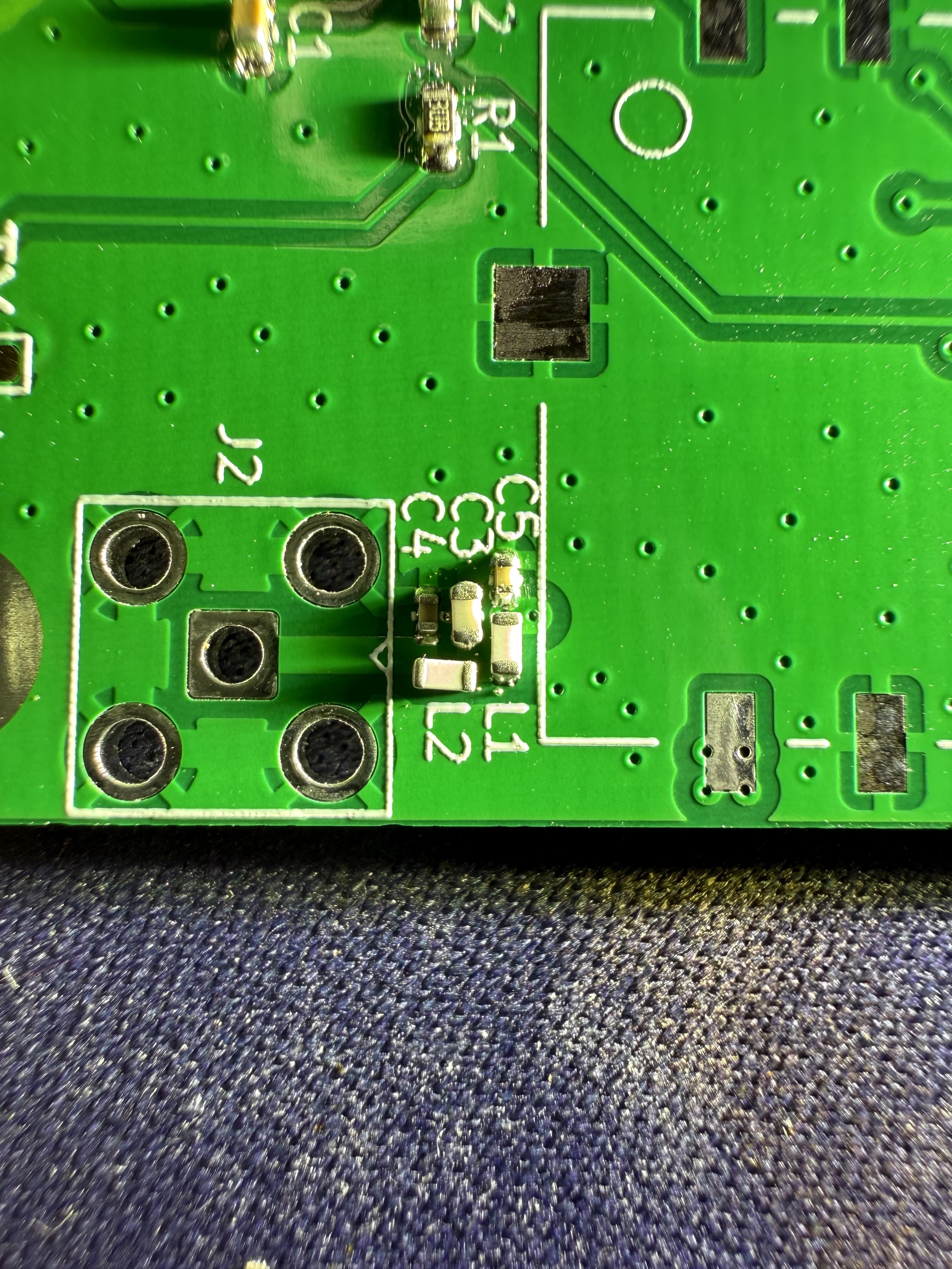 A small portion of a green printed circuit board showing some very small components next to an unpopulated SMA footprint. The components are in a cluster labelled L1, L2, C3, C4, C5 and are a mix of 0402 and 0603 sizes. 